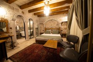 a bedroom with a bed and a table and a tub at Ares Cave Suites in Göreme