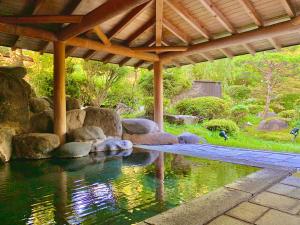 una piscina de agua bajo un pabellón en Ryumontei Chiba Ryokan en Ōyu