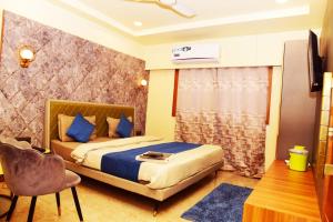 ein Schlafzimmer mit einem Bett, einem Tisch und einem Stuhl in der Unterkunft Hotel satpura inn` in Pachmarhi