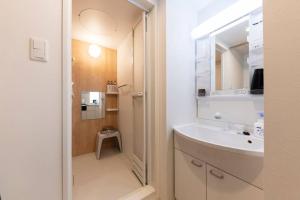 a white bathroom with a sink and a mirror at SECLUSION 千歳MS102 in Chitose