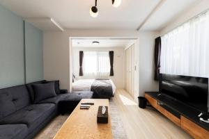 a living room with a couch and a television at SECLUSION 千歳MS102 in Chitose