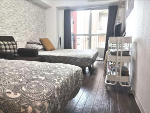um quarto de hotel com duas camas e uma televisão em XL HOUSE-Self Check in- Will send room number and password em Tóquio
