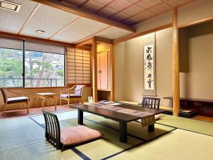 Ryumontei Chiba Ryokan في Ōyu: غرفة مع طاولة وكراسي في غرفة