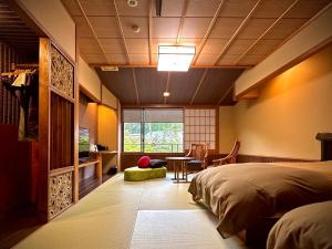 um quarto com uma cama, uma secretária e uma mesa em Ryumontei Chiba Ryokan em Ōyu