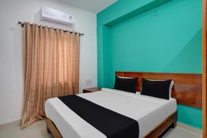 a bedroom with a bed and a blue wall at Hotel O METRO VIEW INN in Bengaluru