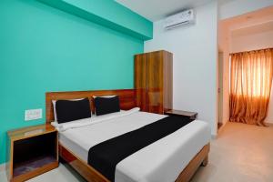 a bedroom with a bed and a blue wall at Hotel O METRO VIEW INN in Bengaluru