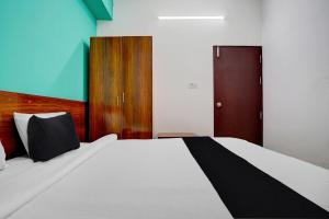 a bedroom with a large bed and a wooden door at Hotel O METRO VIEW INN in Bengaluru
