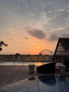 uma piscina com uma banheira de hidromassagem num deque com o pôr-do-sol em Luminor Hotel Legian Seminyak - Bali em Seminyak