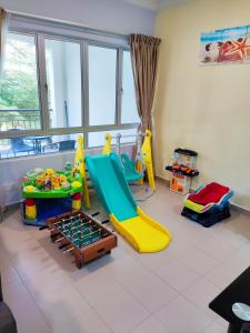 a childrens play room with a slide and play equipment at JoJo Homestay Tiara Residence in Desaru