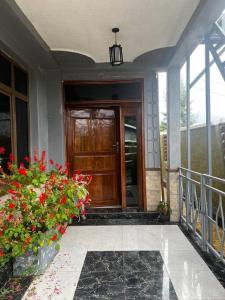 a front door of a house with flowers on a porch at 2 bedroom apartment in Musanze( Benji) in Ruhengeri