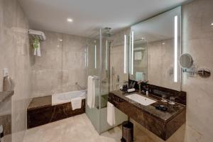 a bathroom with a sink and a shower and a mirror at Vintage Grand Hotel - Formerly Ghaya Grand Hotel in Dubai