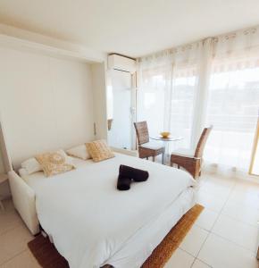 a bedroom with a white bed and a table with chairs at Eden in Saint-Tropez +27 photos