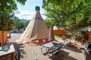 摩押的住宿－Moab RV Resort Glamping Tipi OKTP-53，帐篷配有野餐桌和长凳