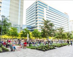 personas sentadas en un parque frente a un edificio alto en Contemporary LUX 1BD Downtown, en Dallas