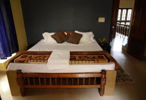 a bedroom with a large bed with white sheets and pillows at Cardamom rock inn Holidays in Pīrmed