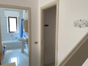 een badkamer met een toilet, een wastafel en een deur bij Casa Viola, San Vito a 25 minuti da Costa Rey e Villasimius in San Vito