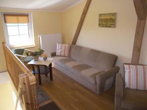 ein Wohnzimmer mit einem Sofa und einem Tisch in der Unterkunft Ferienwohnung Heuboden in Mellenthin