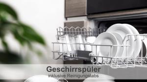 un estante de platos con platos y utensilios en un horno en Gulfhof-Ferien Briese, en Großheide