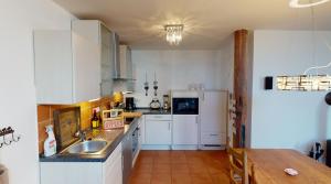 Una cocina con gabinetes blancos y un refrigerador blanco. en Gulfhof-Ferien Briese, en Großheide