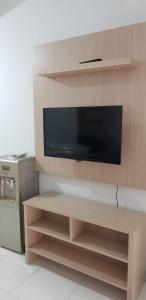 a flat screen tv on a wooden entertainment center at Apartement Ayodhya by Alam Sutera in Tjikokol