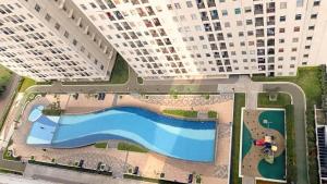 an aerial view of a pool in front of two tall buildings at Apartement Ayodhya by Alam Sutera in Tjikokol