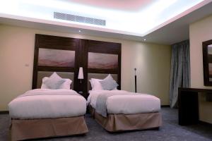 a hotel room with two beds in a room at Helat Hotel in Al Khobar