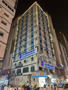 a tall building with blue signs on the side of it at فندق سما السماح Sama Al Samah Hotel in Makkah