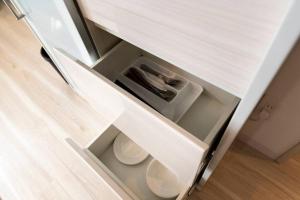 an open drawer in a white kitchen cabinet at SERENADE in Chitose