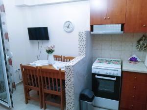 a small kitchen with a table and a stove at Jordan's Neoi Epivates Appartment by the Beach in Neoi Epivates