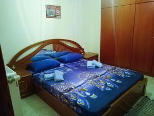 a bedroom with a bed with blue sheets and blue pillows at Jordan's Neoi Epivates Appartment by the Beach in Neoi Epivates