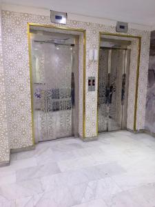 a row of doors in a room with white tiles at فندق سما السماح Sama Al Samah Hotel in Makkah