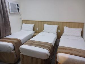 a row of three beds in a room at فندق سما السماح Sama Al Samah Hotel in Makkah +12 photos