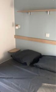 una camera con letto e testiera in legno di Mobil-home Camping - La Marine - Grau du Roi a Le Grau-du-Roi