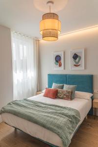 a bedroom with a large bed with a blue headboard at Malvarrosa Beach Stay! in Valencia +67 photos