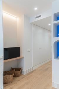 a living room with white walls and a flat screen tv at Malvarrosa Beach Stay! in Valencia