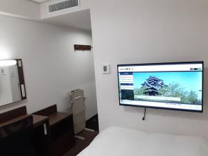 a flat screen tv hanging on a wall in a room at Hotel Alpha-One Matsue in Matsue