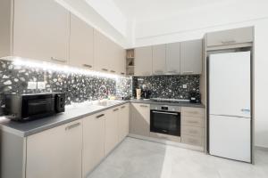 eine Küche mit weißen Schränken und einer schwarz-weißen Tapete in der Unterkunft New Spacious & Stylist Apt in Piräus