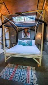 a bed in a room with a canopy at Carabao Lodge - 2 bedroom house, stargazing & pool in El Nido