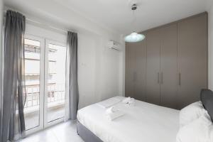 1 Schlafzimmer mit 2 Betten und einem großen Fenster in der Unterkunft New Spacious & Stylist Apt in Piräus