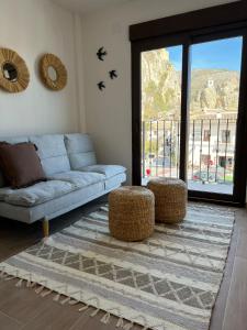 a living room with a blue couch and two stools at Olcina apartments in El Castell de Guadalest