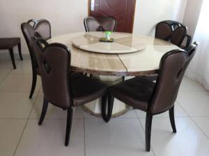 uma mesa de jantar com cadeiras de couro à volta em Amariah Guest House em Kasane