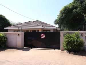 a fence in front of a house at Amariah Guest House in Kasane