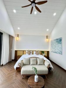 a bedroom with a bed and a ceiling fan at Tropicana Hồ Tràm - Seashell Villa in Ho Tram