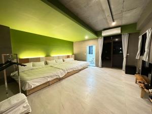 a bedroom with a bed with a green wall at 21 Tao Heung Homestay in Jiaoxi