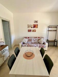 ein Wohnzimmer mit einem Tisch und einem Sofa in der Unterkunft un sogno sul lago in Castiglione del Lago