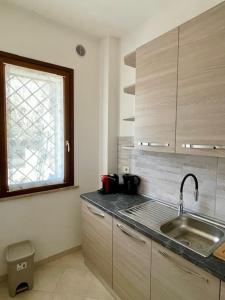 eine Küche mit einem Waschbecken und einem Fenster in der Unterkunft un sogno sul lago in Castiglione del Lago