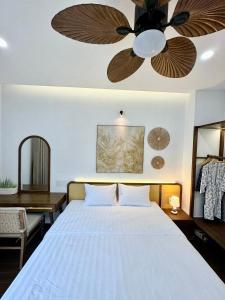 a bedroom with a bed with a ceiling fan at Tropicana Hồ Tràm - Seashell Villa in Ho Tram