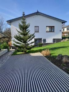 una casa con un árbol en una entrada de metal en Ferien bei Naus - Ferienwohnung, en Marburg an der Lahn