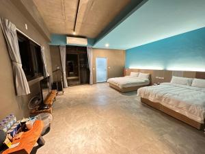 1 dormitorio con 2 camas y TV. en 21 Tao Heung Homestay, en Jiaoxi