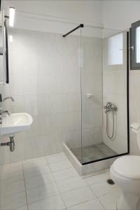uma casa de banho com um chuveiro, um WC e um lavatório. em VIRI VIRI APARTMENTS em Lilikás